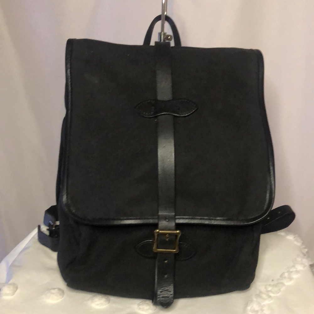 FILSON black tin cloth backpack. Leather straps with quilted interior.